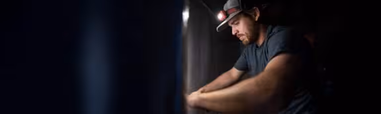 Crawl space encapsulation specialist working on a vapor barrier installation