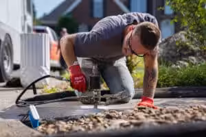 Certified Foundation Specialist injecting polyurethane under sidewalk to level the concrete