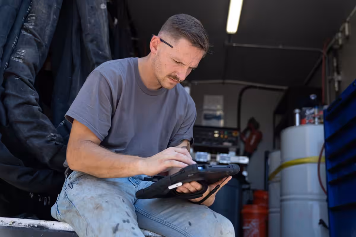 Certified Foundation Specialist review his tablet in a work truck