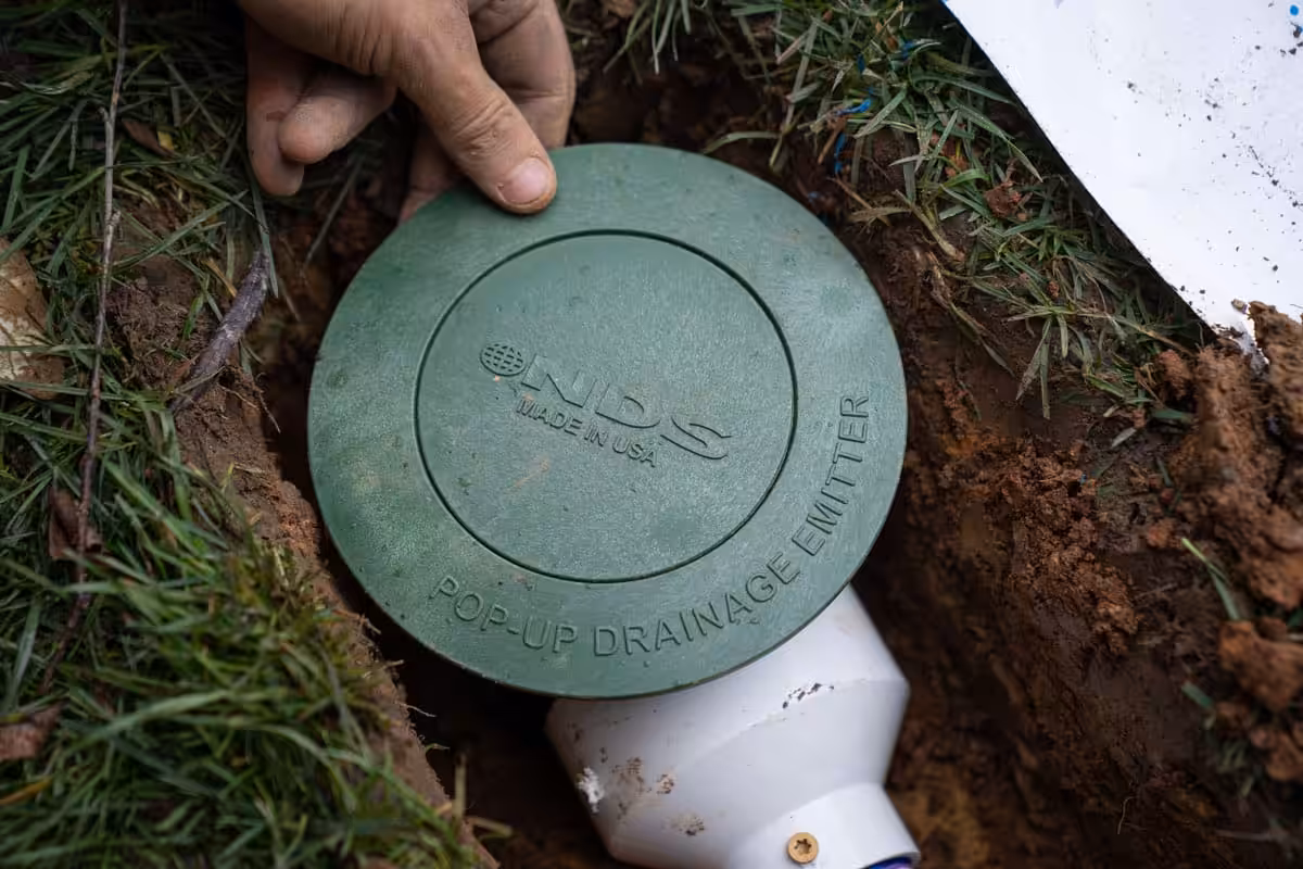 Crawl space waterproofing discharge NDS drainage emitter in a yard