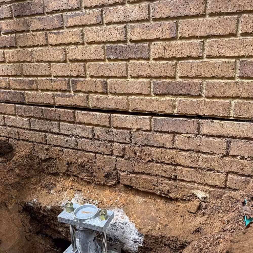 Horizontal cracks in a home's foundation being repaired with helical piers