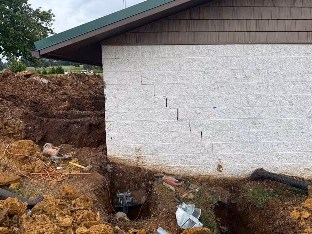A building on a golf course with repaired walls after helical pier installation