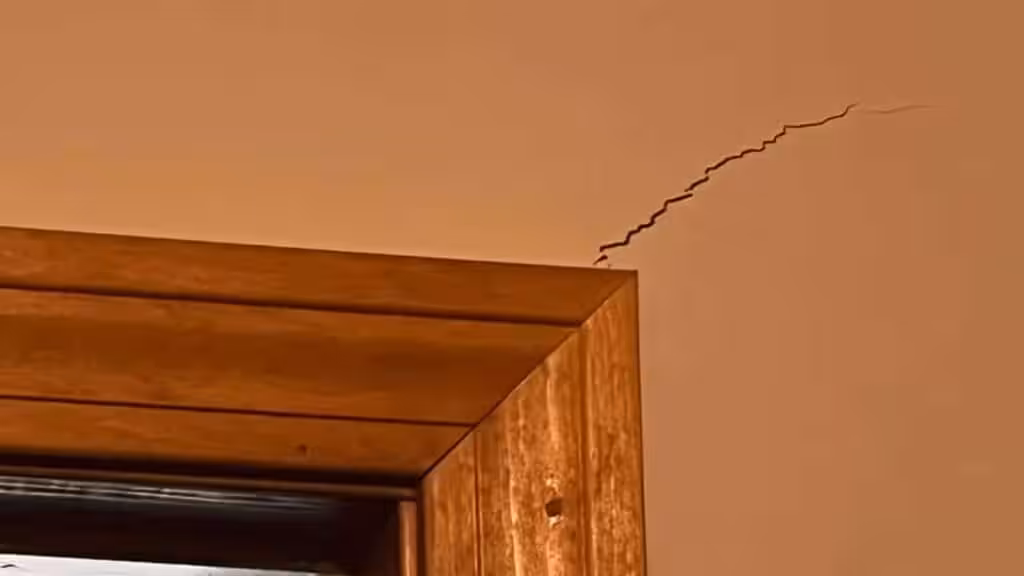 A diagonal drywall crack by a door frame