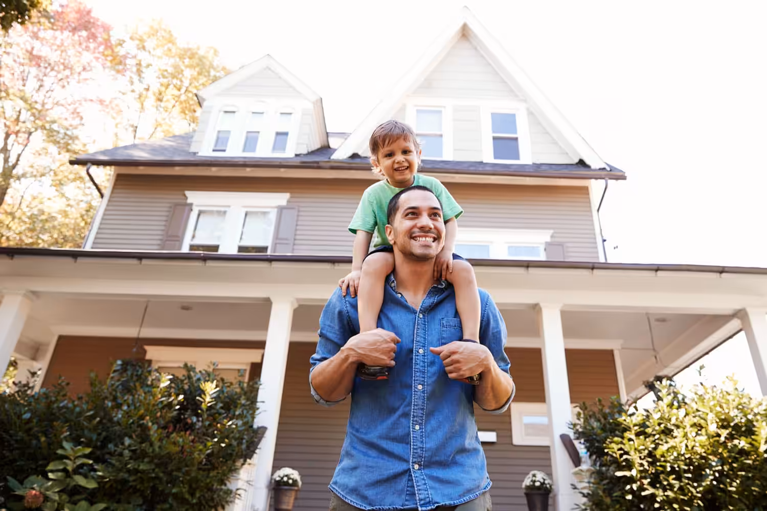 A man and a kid looking happy in front of a home in Milwaukee Milwaukee, WI