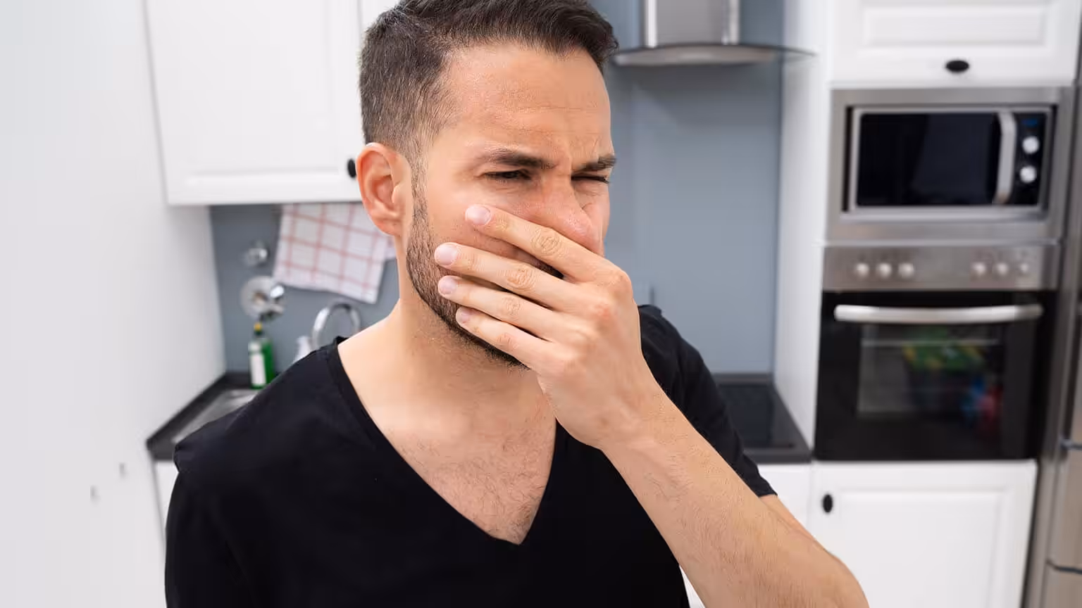 Man plugging his nose after smelling something