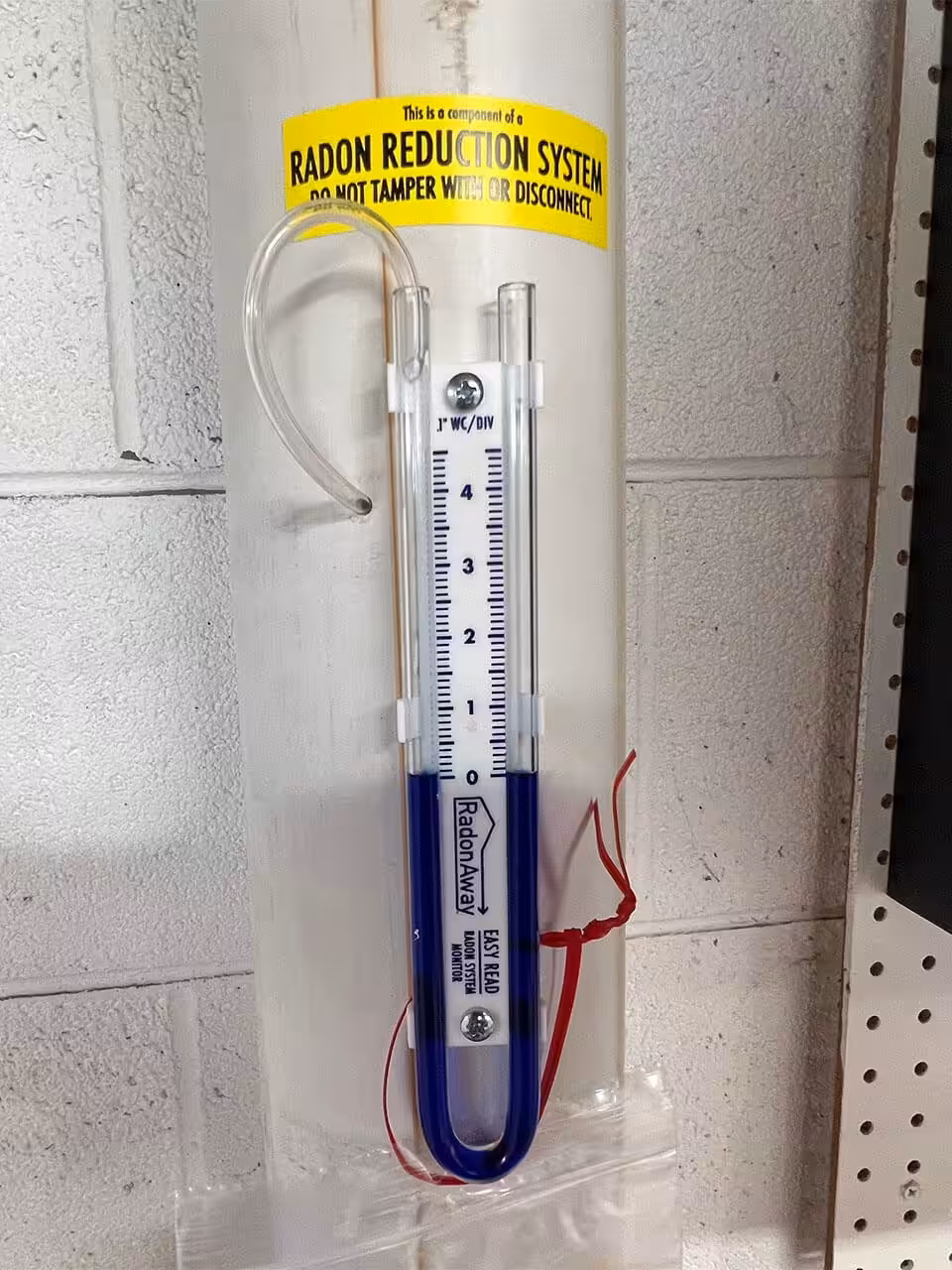 A component of a radon mitigation system that says do not tamper with